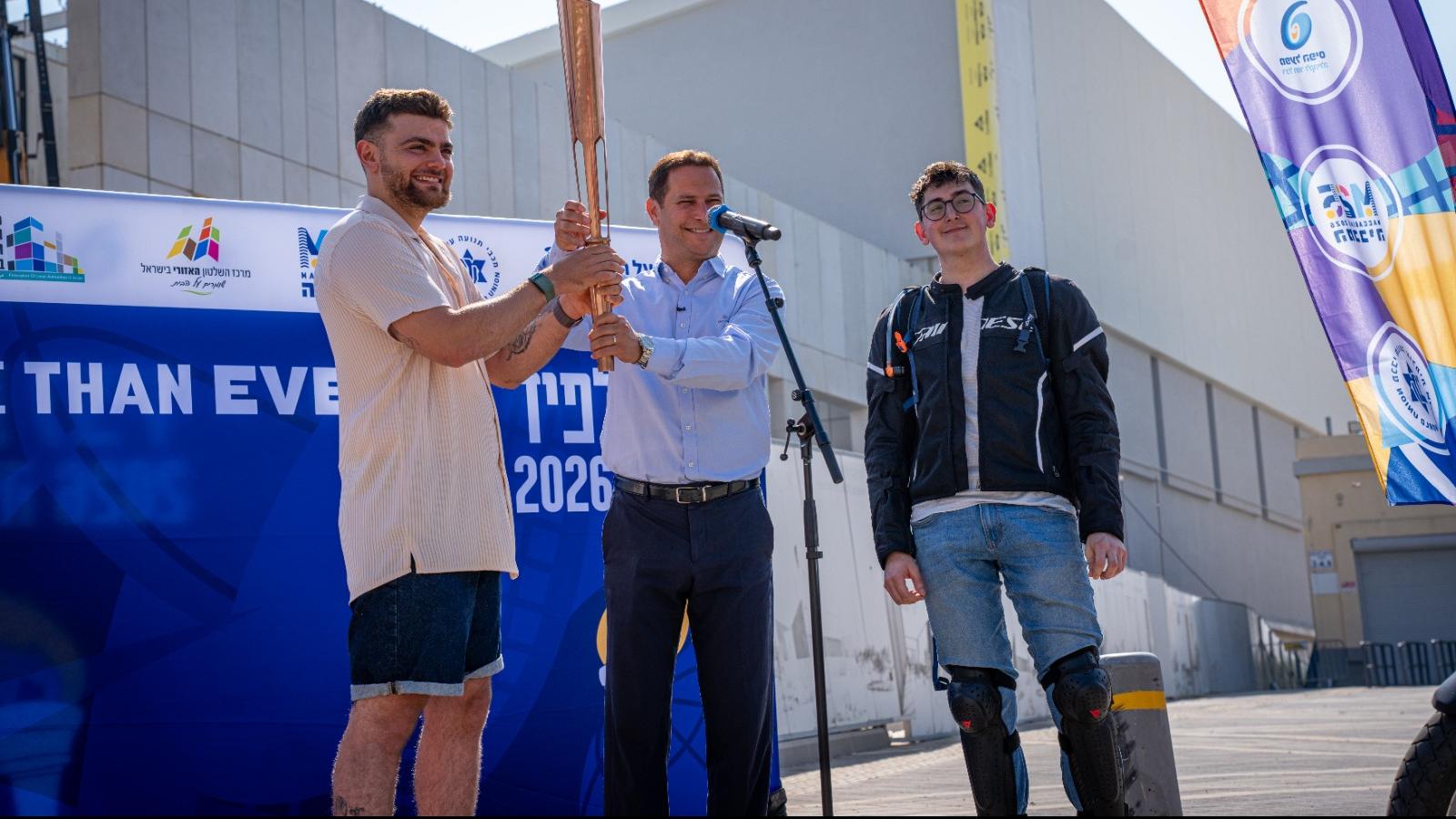 רז קינסטליך, ראש עיריית ראשון לציון מניף את הלפיד עם סרן תום חיים ביביטקו, שנפצע קשה בעזה ונמצא בעיצומו של תהליך שיקום
