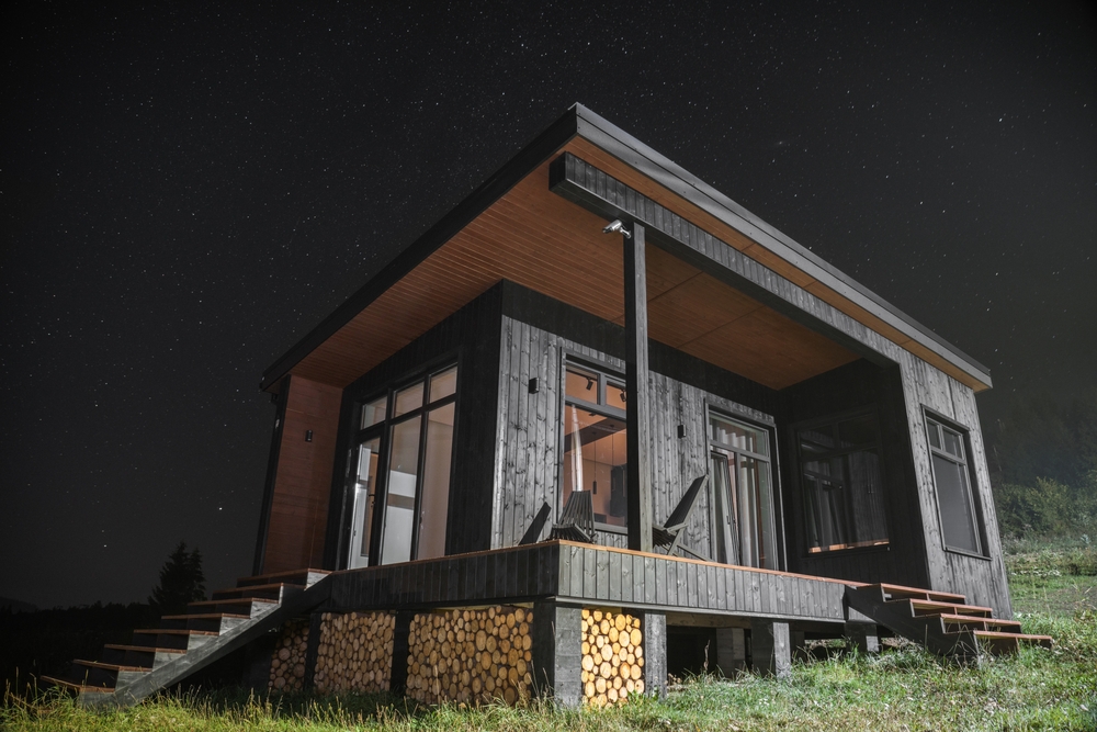 Modern wooden tiny cabin at night with stars. Photo: Ayman alakhras / Shutterstock